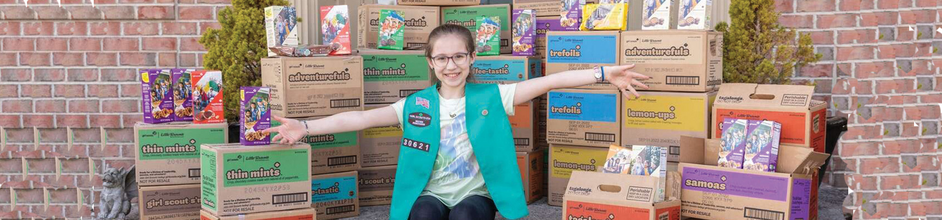  girl with her arms out in front of stacks of cookie cases 