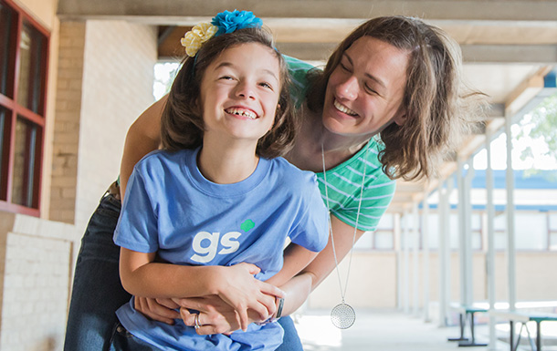 Parent and girl hugging and laughing