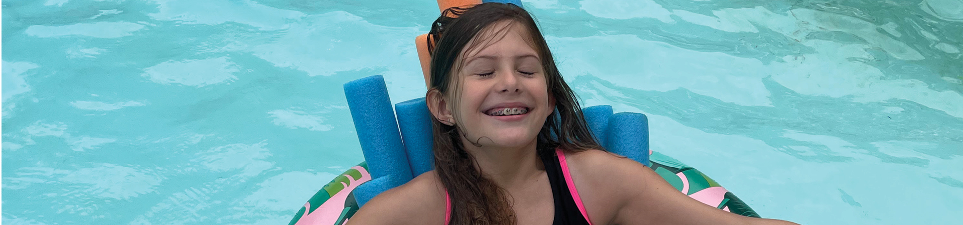  Girl in a pool float smiling 