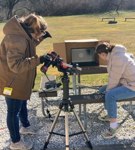 two girl scouts using a special camera to capture images of the moon