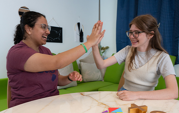 adult volunteer and older girl scout high fiving