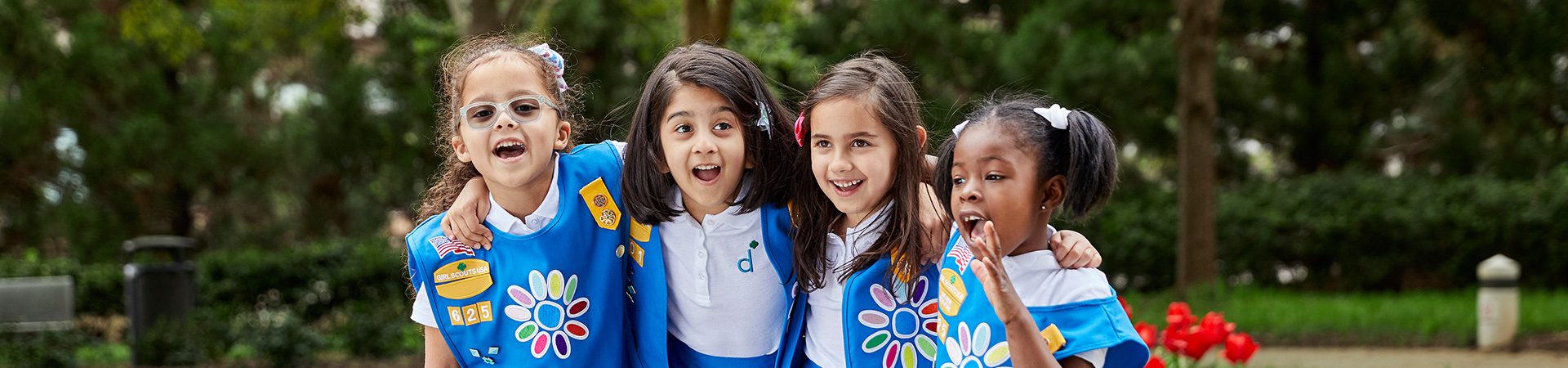  Girl Scout Daisies with their arms around each other, exclaiming 